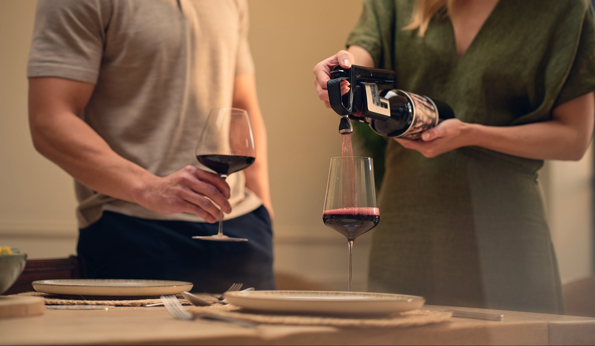 two people enjoying red wine with coravin