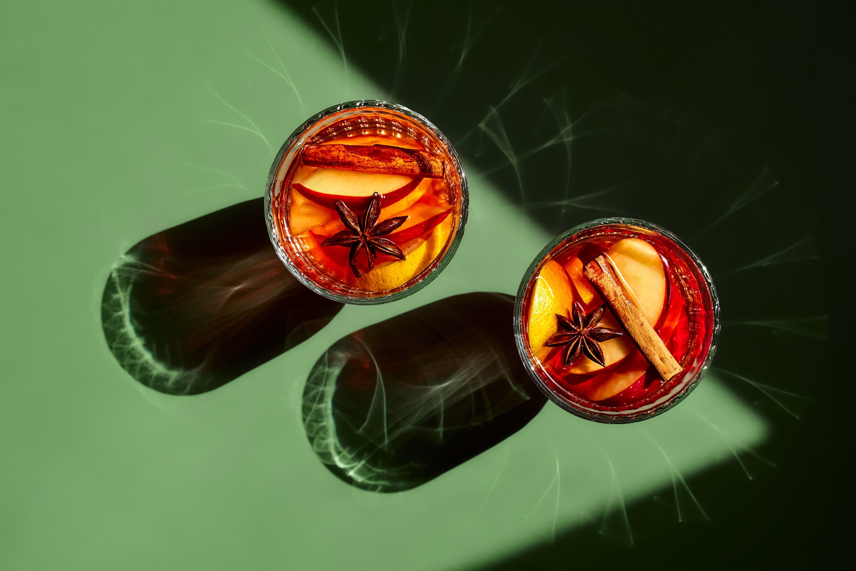 what is mulled wine - two glasses of mulled wine against green