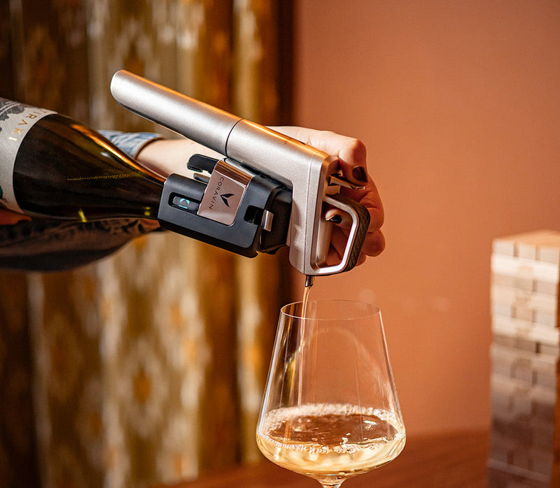 person pouring white wine with Coravin