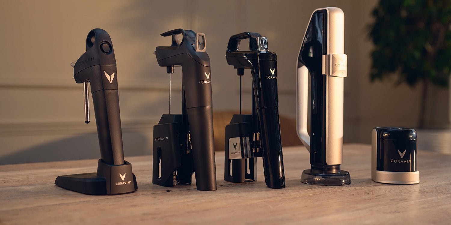 Collection of Coravin wine bottle openers on a wooden surface with a blurred background