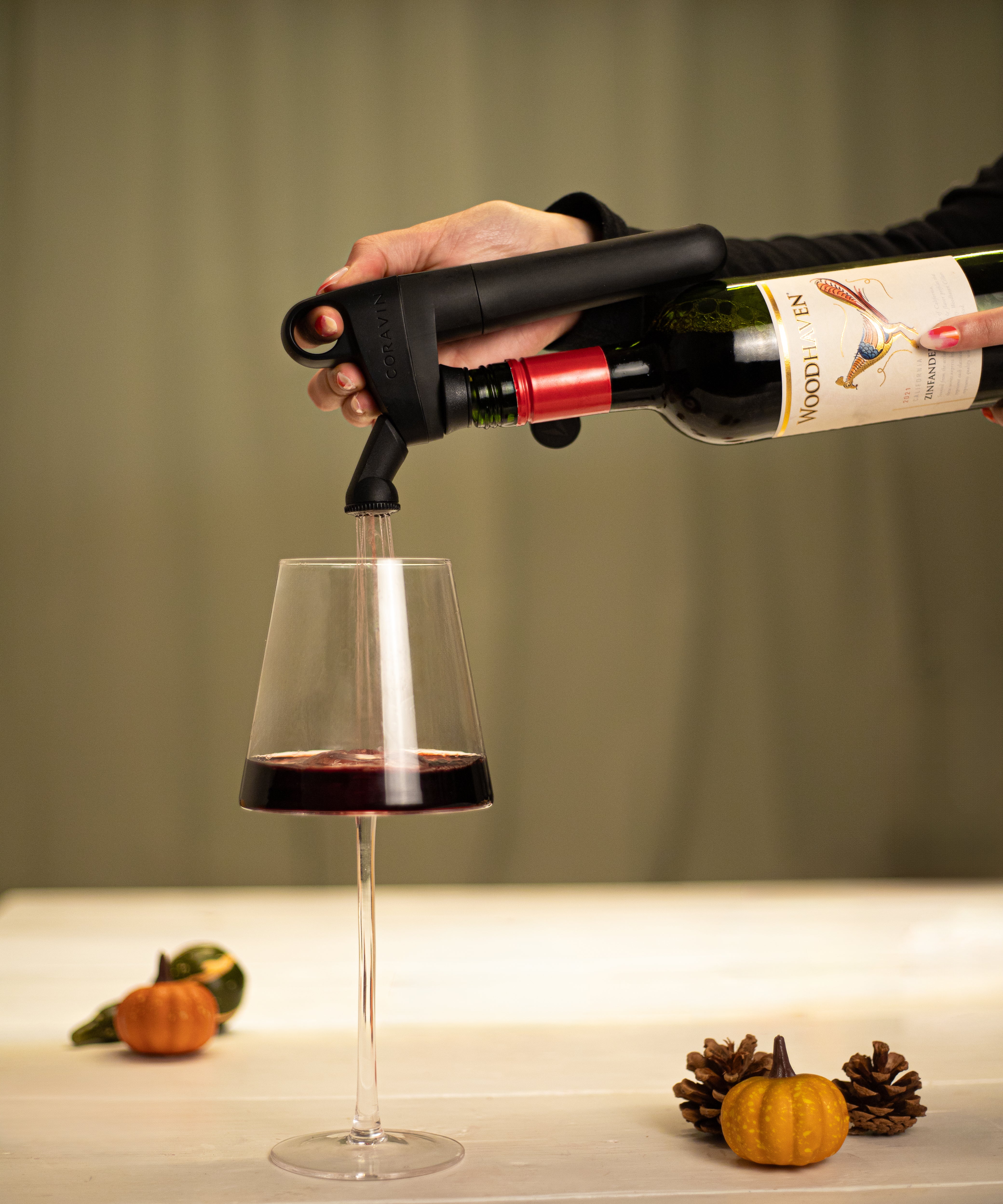 Coravin pivot pouring wine into glass with pumpkin decoration